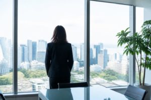 現地オフィスの明るい執務室。人物は後ろ姿のみ